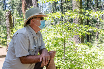 Older man wearing mask hiking