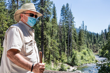 Senior hiking in mountains with mask on