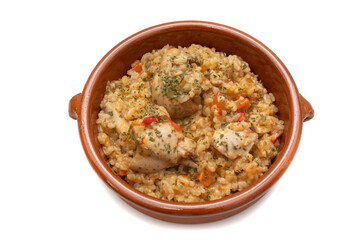 Chicken rice stew served in a clay bowl, isolated on white background. Spanish food concept.