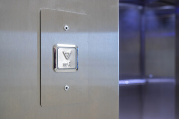 Metallic elevator call button with arrow and braille © SFotoz