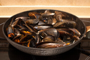 Cooking mussels in a pan. Mussels are perfect in endless fish recipes, but the simplest and most traditional in Galicia are steamed mussels.