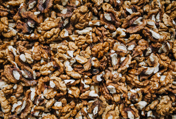 Background, texture of brown walnuts, peeled nuts. Food photography, top view.