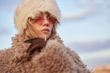 Sale concept: attractive glamour young woman in stylish clothes - artificial fur coat and hat,...