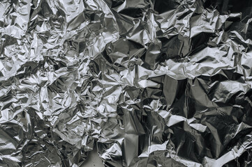 Background, texture of silver shiny foil, colored crumpled wrapping paper. Photo, top view, copy...
