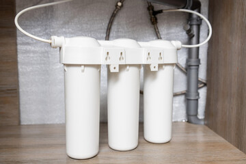 House water filtration system. Installation of water purification filters under kitchen sink in...