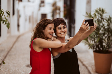 Couple of friends doing tourism during the summer. Taking fun photos together with your smartphone. Lifestyle