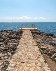 Fototapeta na wymiar Paysage en bord de mer sur le Cap d'Antibes avec une avancée en pierres et un observatoire du panorama 