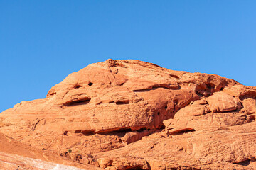 Fototapeta premium Overton, Nevada, USA - February 24, 2010: Valley of Fire. Atlantic Bunker like red dock dome under blue sky. Cracks and niches galore.