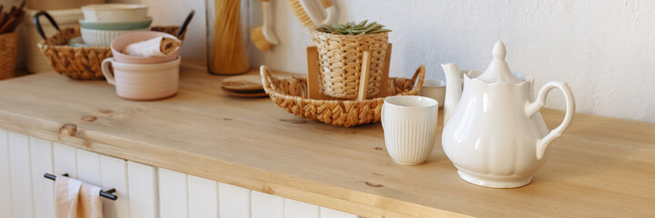 Banner white cup of tea with a teapot on the background of the kitchen interior.