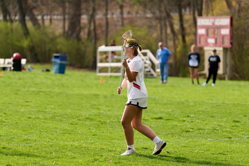 Obraz premium SEWICKLEY, PA, USA - APRIL13th 2022: Teenage girls from Sewickley Academy play senior school varsity lacrosse game against Freeport High School. There were lots of goals and action on this sunny day.