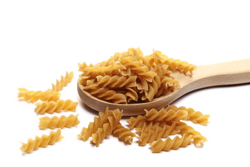 Pile wholemeal, integral pasta spirali in wooden spoon isolated  on white 