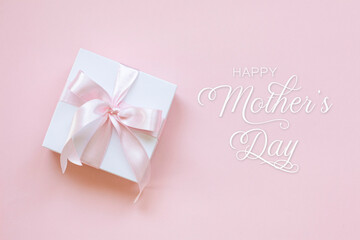 Happy Mothers Day lettering and a gift box on pink background.
Happy mothers day lettering on pink background.