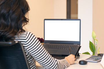Woman working and using laptop with mock up white screen at office