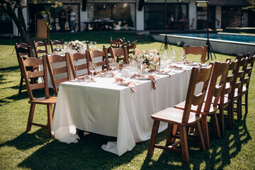 Fototapeta na wymiar rectangular wedding festive set table in the patio, garden in nature