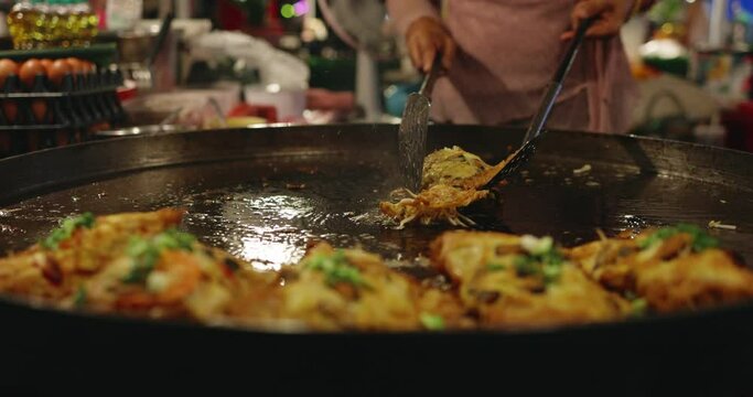 Slow motion Chef using giant pan fried clams, delicious street food in Thailand.