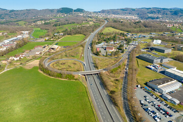 Aerial view of highway road intersection with fast moving heavy traffic. Intercity transportation with many cars and trucks