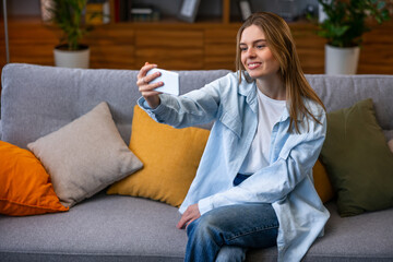 Technology and people concept - smiling woman with smartphone having video call at home