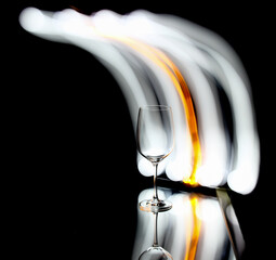 Light painting on a mirror with reflections and a wine glass