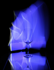 Light painting on a mirror with reflections and a wine glass