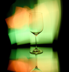 Light painting on a mirror with reflections and a wine glass
