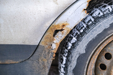 Rust on the door and fender of the car. Consequences of salt, snow, reagents in the north.