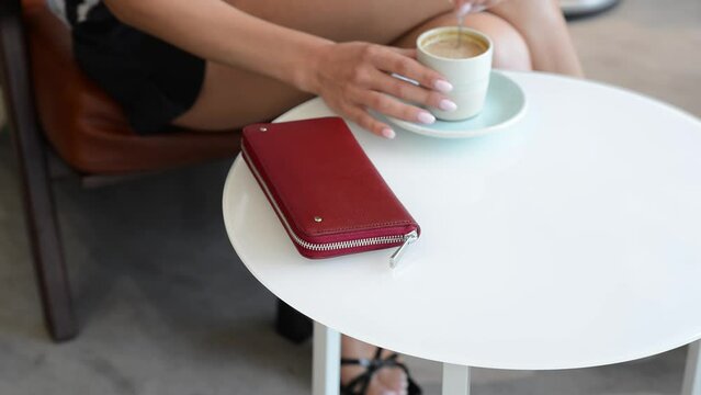 A young girl sits down at a table with a purse