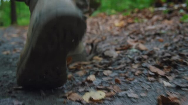 Soldier male legs in army boots walk falls to the ground wounded in camouflage uniform. In forest. Training. Imitation of hostilities