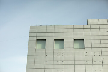 Modern building is gray in color. Facing panel on office building.