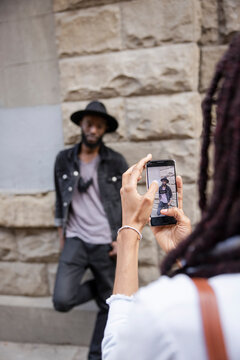 Woman with camera phone photographing boyfriend