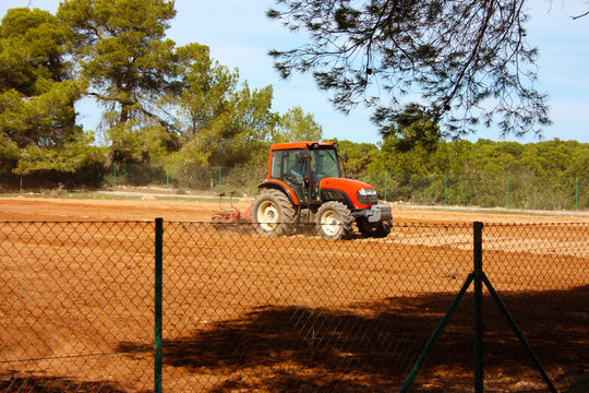 farmer from the balearic islands drives his tractor plowing the arid soil of his vegetable garden in formentera in summer