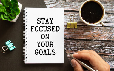 Inspirational quote - Stay focused on your goals. With text message on white paper book