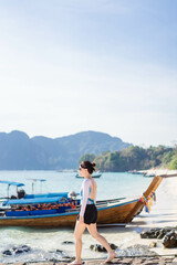 Young asian woman travel on summer ocean Andaman sea at Thailand island on Krabi.Swimsuit Fashion sexy Korean asian woman girl on sea beach.Sunscreen sunglasses skin care cream.Nature environment.