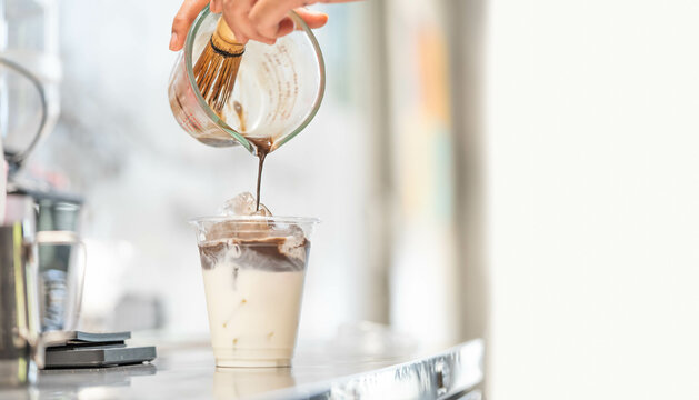 Barista make iced Hojicha milk latte.Food menu beverage in Tokyo Japan.Delicious milk tea Hojicha latte..Homemade ice tea.Japanese tea which uses roasted tea leaves.tasty drink.milk latte.Cafe menu.