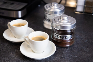 two cups of black coffee on the kitchen table