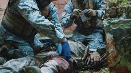 In forest near old building combat medic records information about a wounded soldier when the tourniquet was applied. Military concept