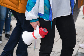 Earth Day demonstration, young person holding a megaphone; activism, protest.