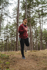 One man stretching in nature in forest or public park young adult caucasian male preparing for outdoor training in day standing alone real people copy space full length
