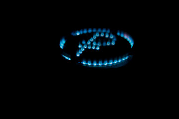 The flame of a gas burner in the dark with the symbol of the Russian ruble. The concept of natural gas supply from Russia to Europe. Isolated black background.
