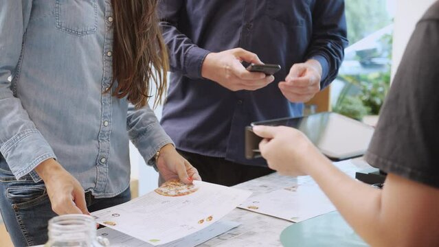 Closeup hands of customer man and woman buying coffee and paying together with wallet digital for banking to barista at cafe, scan payment with QR code technology, small business, startup business.