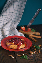 Fresh delicious puff pastry with sweet berries on dark wooden table, closeup