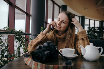 Smiling woman sitting on kitchen sofa talking by videocall dating online looking at phone. Video blogger vlogger recording vlog at home. Lifestyle vlogging concept, head shot