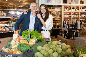Portrait of a happy young man and girl in a supermarket, who came to shop