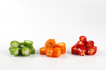 Red chili, orange chili, green chili, fresh pepper sliced on a white background. close-up view on white.