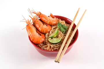 Instant noodles spicy tom Yum kung. Tom Yum kung in a red bowl on a white background top view with chopsticks beside a bowl
