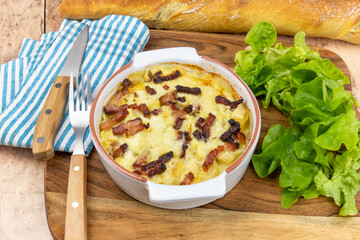 top view of a tartiflette in a dish on a wooden board