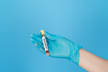 Hand holding test tube of blood with the inscription leukemia.