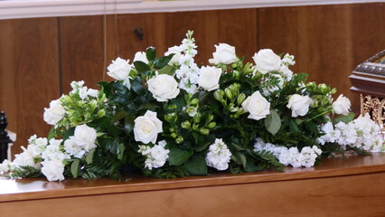 closeup shot of a funeral casket or coffin in a hearse or chapel or burial at cemetery
