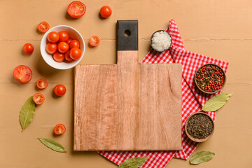 Fototapeta na wymiar New cutting board with tomatoes and spices on beige background