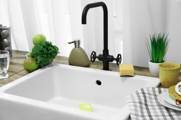 Fototapeta na wymiar Sink with sponge for dish washing and dirty dishware on counter