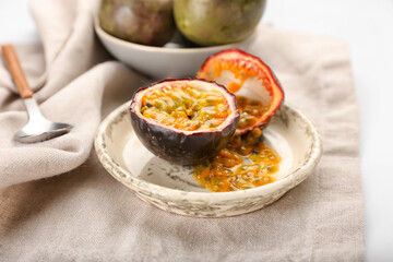 Plate with delicious cut passion fruit on white background, closeup